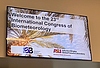 Bildschirm zeigt ein Foto mit Palmen und Himmel und der Aufschrift "Welcome to the 23rd International Congress of Biometeorology". Die Logos der International Society of Biometeorology und der Arizona State University sind ebenfalls abgebildet. 